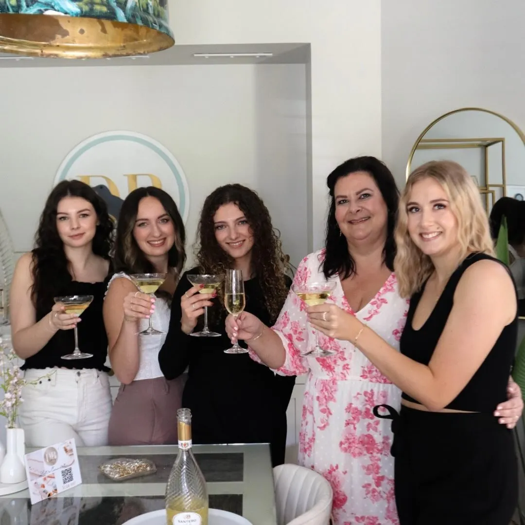 Friends toasting with champagne coupes at a Dirty Bird event